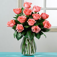 This arrangement of 12 pink roses in a glass vase is classy, minimal and perfect for those who have an elegant taste. Hand gathered fresh long stem pink roses are arranged in a clear glass vase. Green leaves harmoniously heighten the gracious look of the pink roses. Sprinkle some water droplets and the sweet smelling roses are ready to be gifted. This arrangement makes for a perfect professional or personal gift.