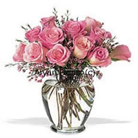 12 pink roses are neatly placed in a clear glass vase. Fresh ferns hang graciously amidst the pink roses. The vintage shape of the glass vase adds a classic look. This one makes for a sweet surprise for your friends and loved ones. Place it on a centerpiece or on a dinning table, and it will brighten up the space as well as everyone's day. Medium in size and elegant, this classic arrangement suits all occasions.