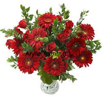 Faith and love comes together with this intense looking bunch of red Gerberas and Roses. The contrasting green fillers along with the bunch not only looks beautiful, but also depicts prosperity and affluence of a human mind. The slender vase shows the number of emotions that can stay in a one heart and can still look beautiful. Passion and desire along with the innocence makes these flowers a perfect gift for someone you love!