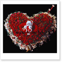 Heart Shaped Arrangement Of 100 Red Roses With a Teddy Bear Placed In The Center Of The Arrangement