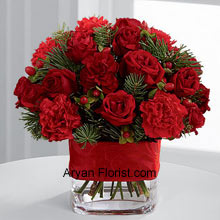 Redness galore with these bright red spray roses, red mini carnations, burgundy mini carnations, red hypericum berries that fill your house with warmth and affection for each and every person who comes to wish to you on this holiday season. The redness is balanced very thoughtfully with the assorted holiday greens and all together they are arranged in a clear glass vase that is bedecked with a rich red ribbon. So gracefully celebrate your festivities with this lovely bunch! (Please Note That We Reserve the Right to Substitute any Product with a Suitable Product of Equal Value in Case of Non-Availability of a Certain Product)