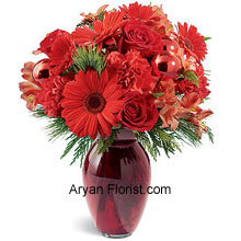 Roseate colored vase with out of the world pretty crimson blossoms is perfect for the gift or for self too. The red Carnations, roses, Gerbera daisies, and alstroemeria are interwoven into this glazed vase that you will alter your idea of giving it away! This will tantalize your heart and will become one of the keep sakes in your list of vital festivity items. The holiday greens complement the entire range of reds and make it plush! (Please Note That We Reserve the Right to Substitute any Product with a Suitable Product of Equal Value in Case of Non-Availability of a Certain Product)