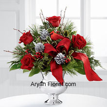 Elegance at its best can be observed through this arrangement of the bunch with rich red roses and variegated holly, assorted holiday greens, silver pine cones, and branches. The lovely curvaceous vase holds these flowers with pride and utmost responsibility which allows us to ponder upon how Jesus has been taking responsibility of each one of us since eternity. So peeps, with this thoughtful note, welcome the season with this pretty arrnagement. (Please Note That We Reserve the Right to Substitute any Product with a Suitable Product of Equal Value in Case of Non-Availability of a Certain Product).